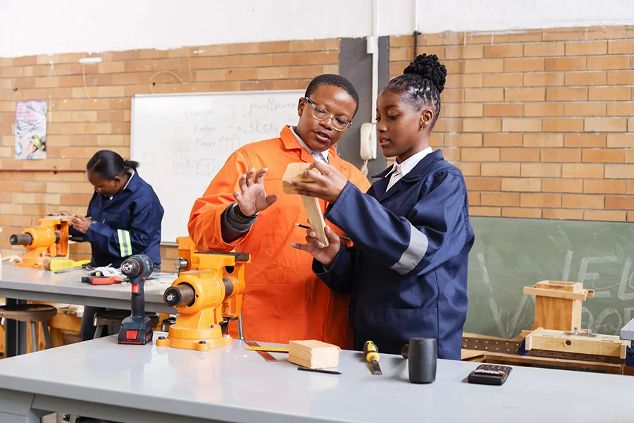 Two students working together in a woodworking shop.