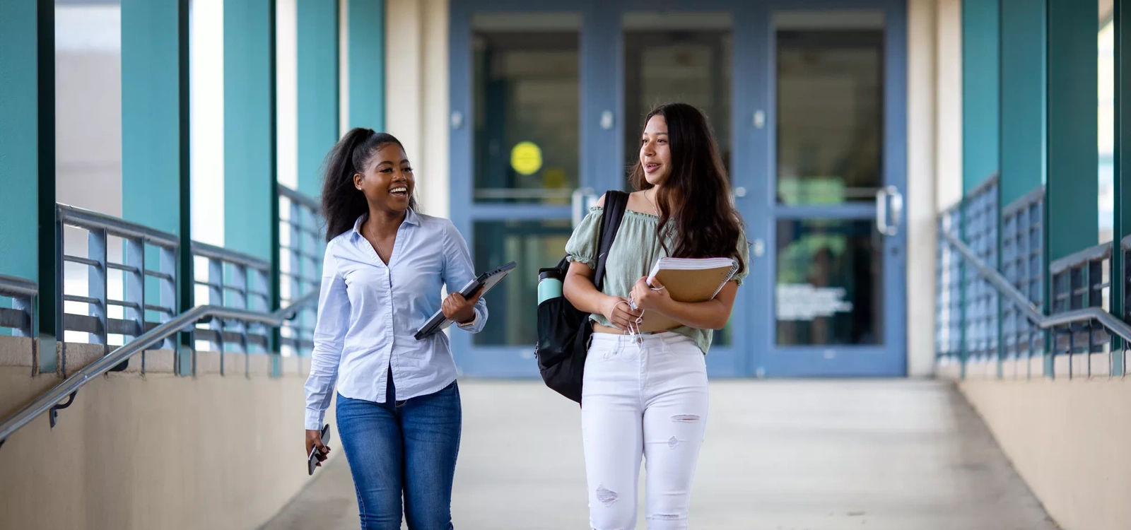 Two students walk outside a school building
