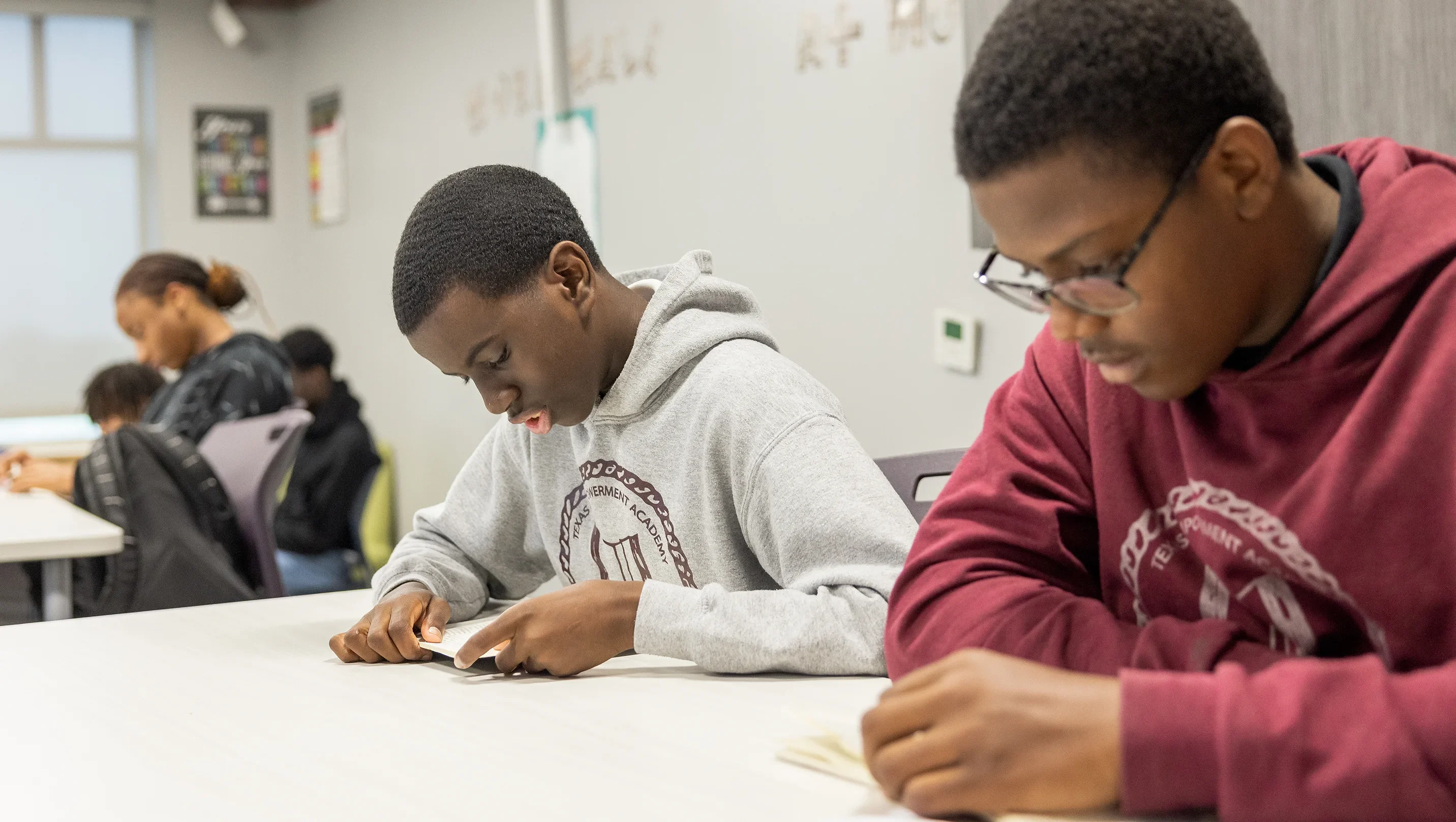 Two students read at a school desk.