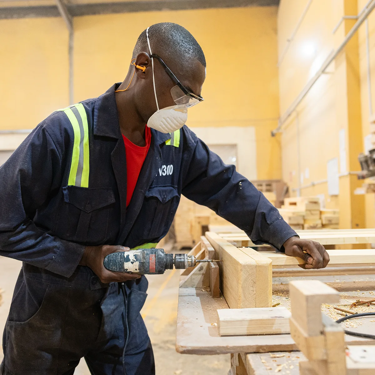 A Moko employee drills into wood in a workshop.