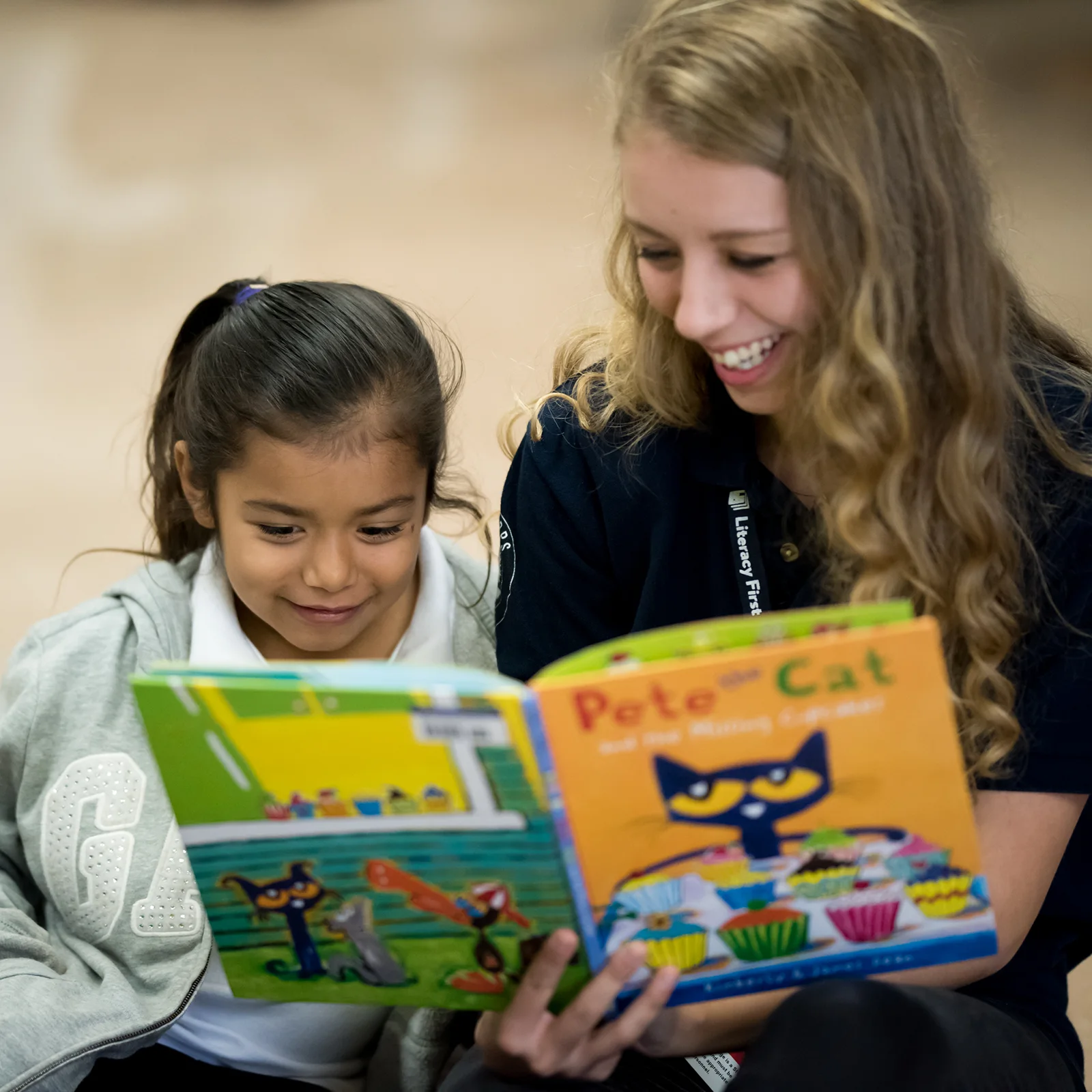 A Literacy First tutor reads a book with a student.