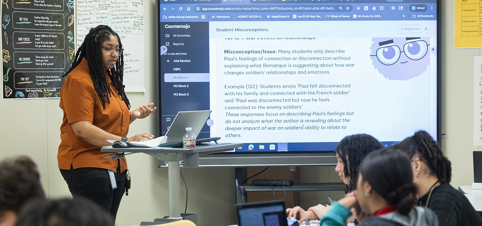 A teacher stands in front of a classroom of students.
