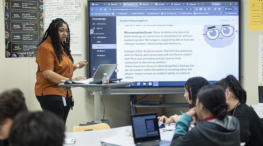 A teacher stands in front of a classroom of students.