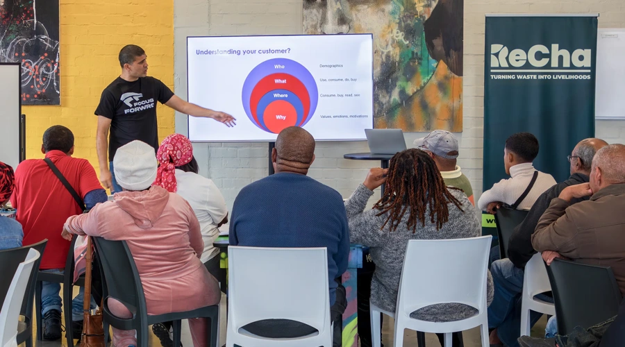An RLabs staff person gives a presentation to a room of people.