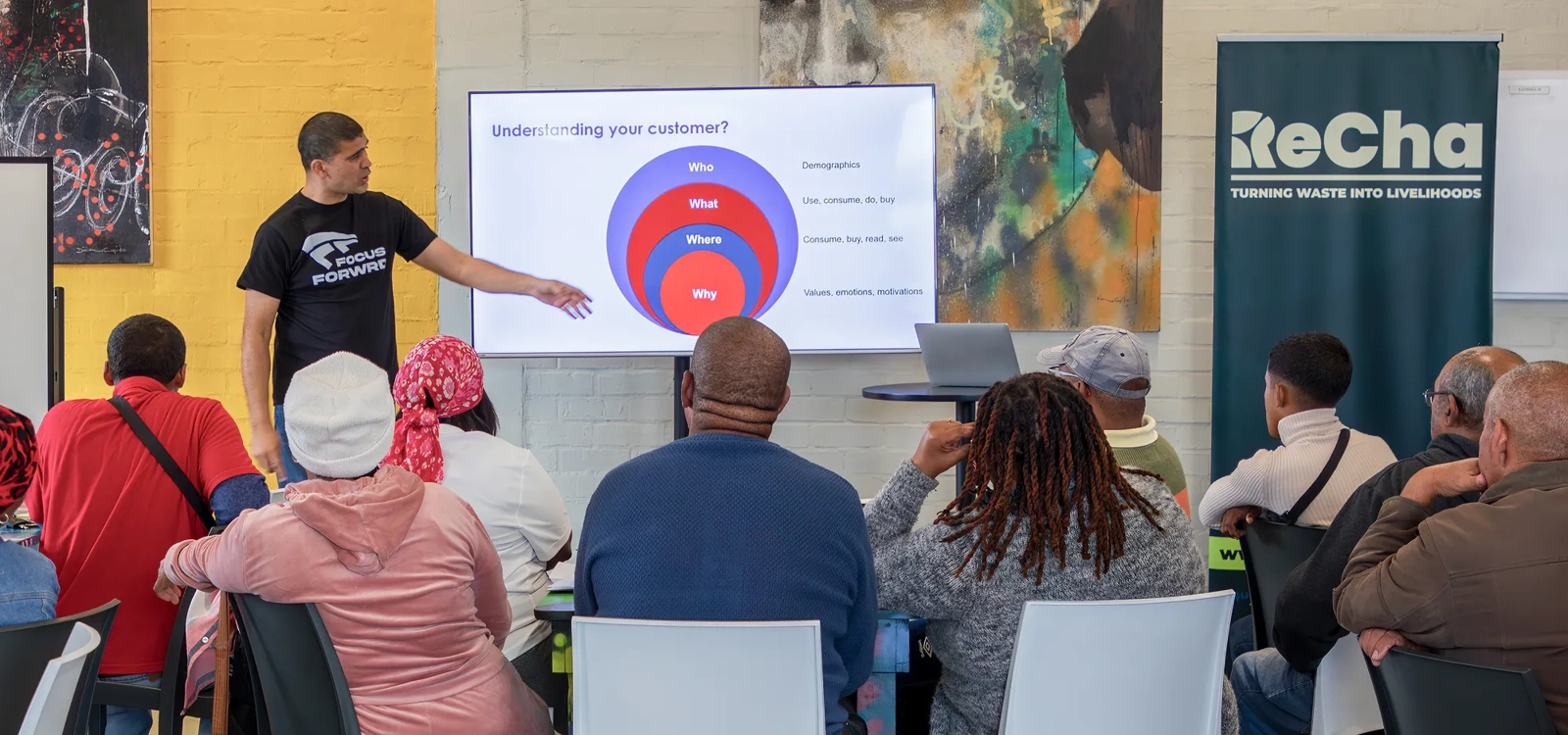 An RLabs staff person gives a presentation to a room of people.