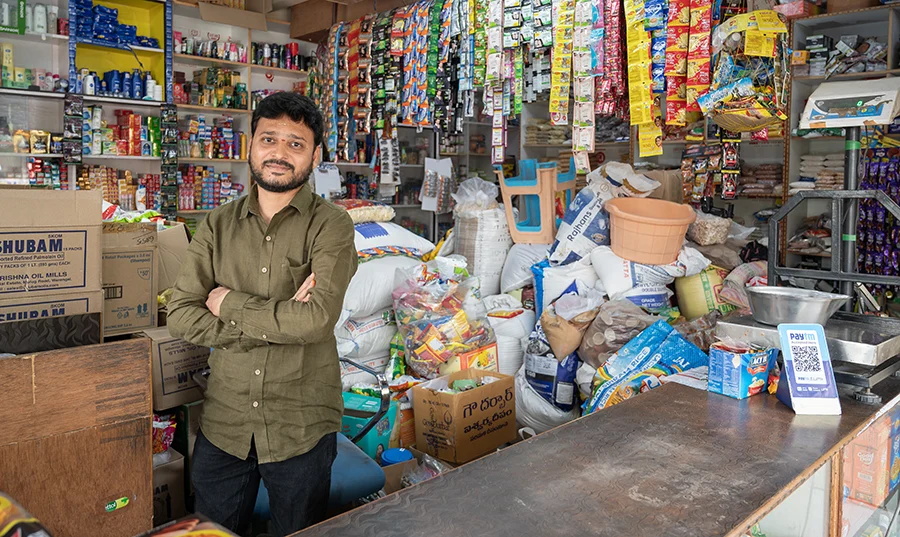 A small business owner stands in his shop.
