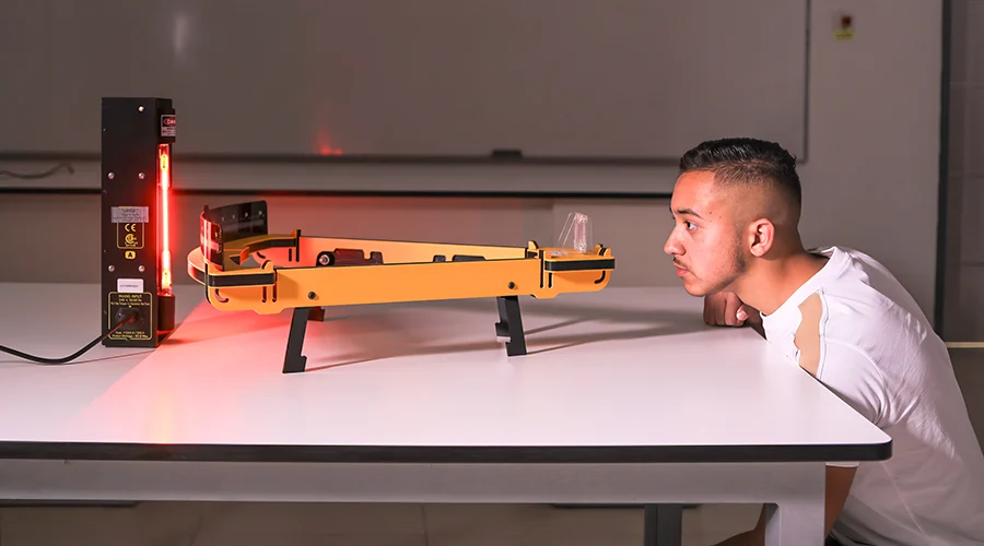 A student conducts an experiment in a Physics class.
