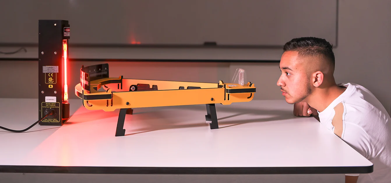 A student conducts an experiment in a Physics class.