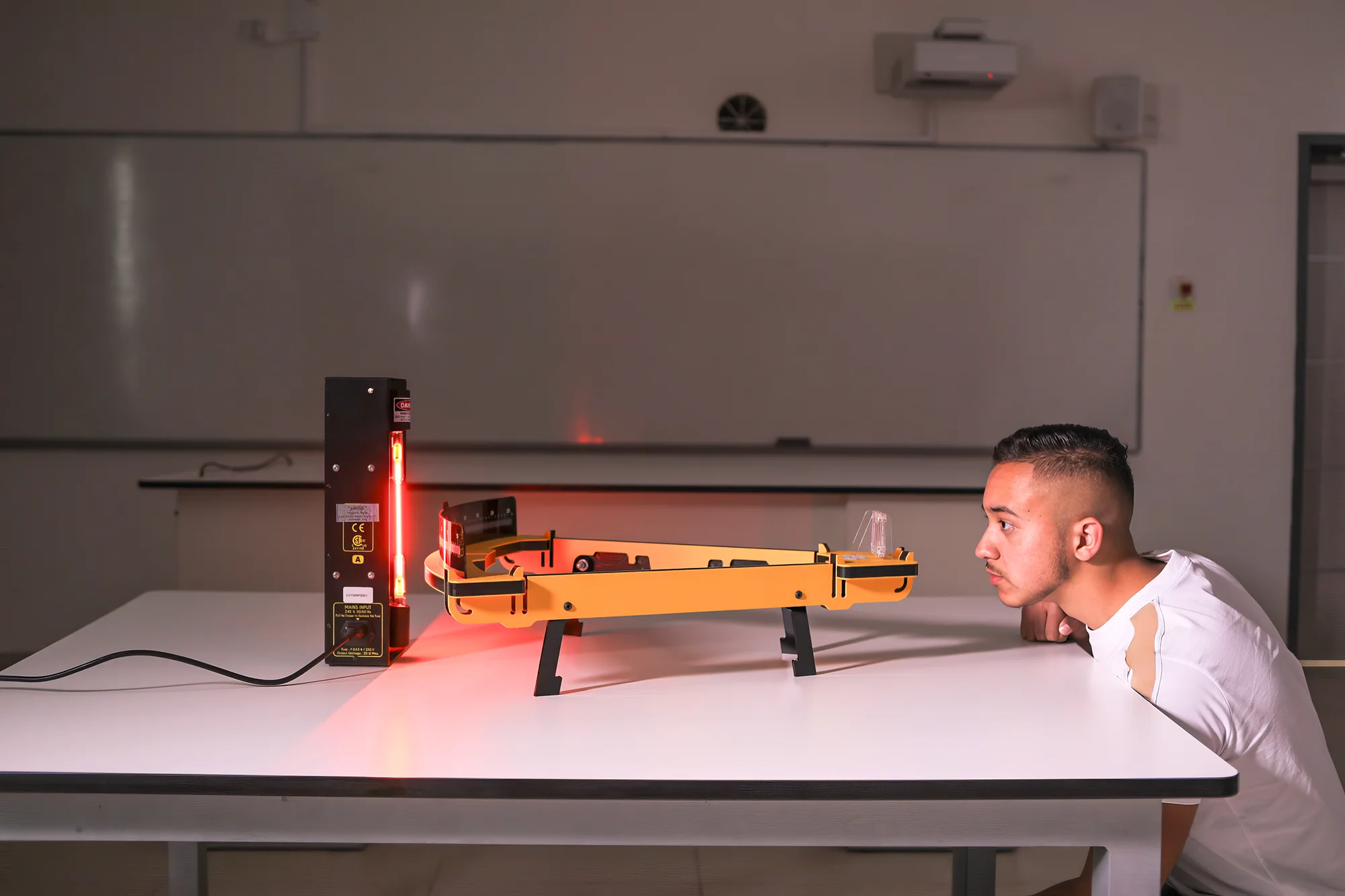 A student conducts an experiment in a Physics class.