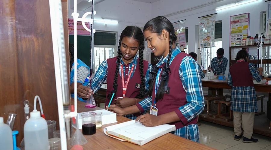 Two students work on a chemistry project in school.