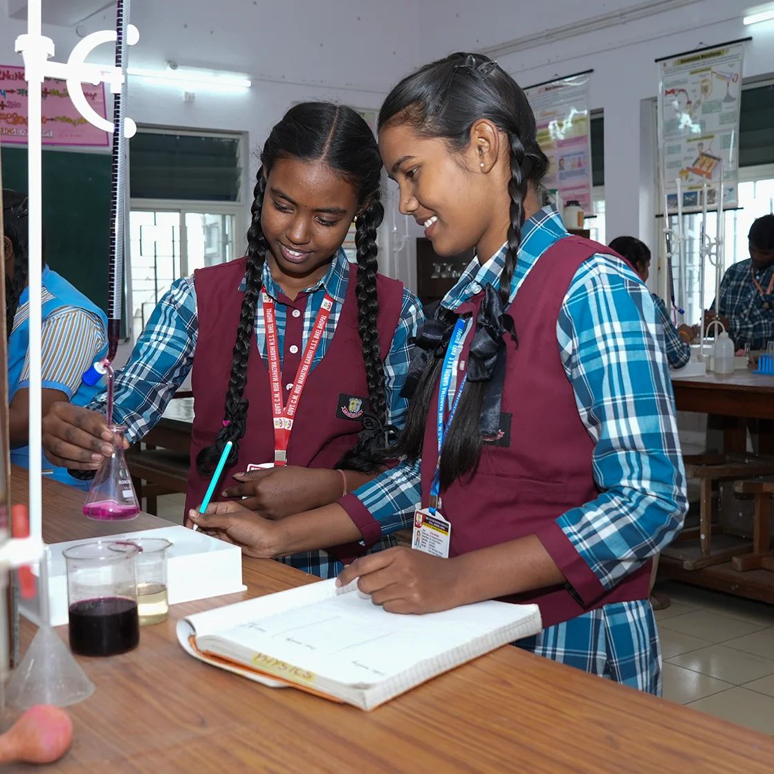 Two students work on a chemistry project in school.