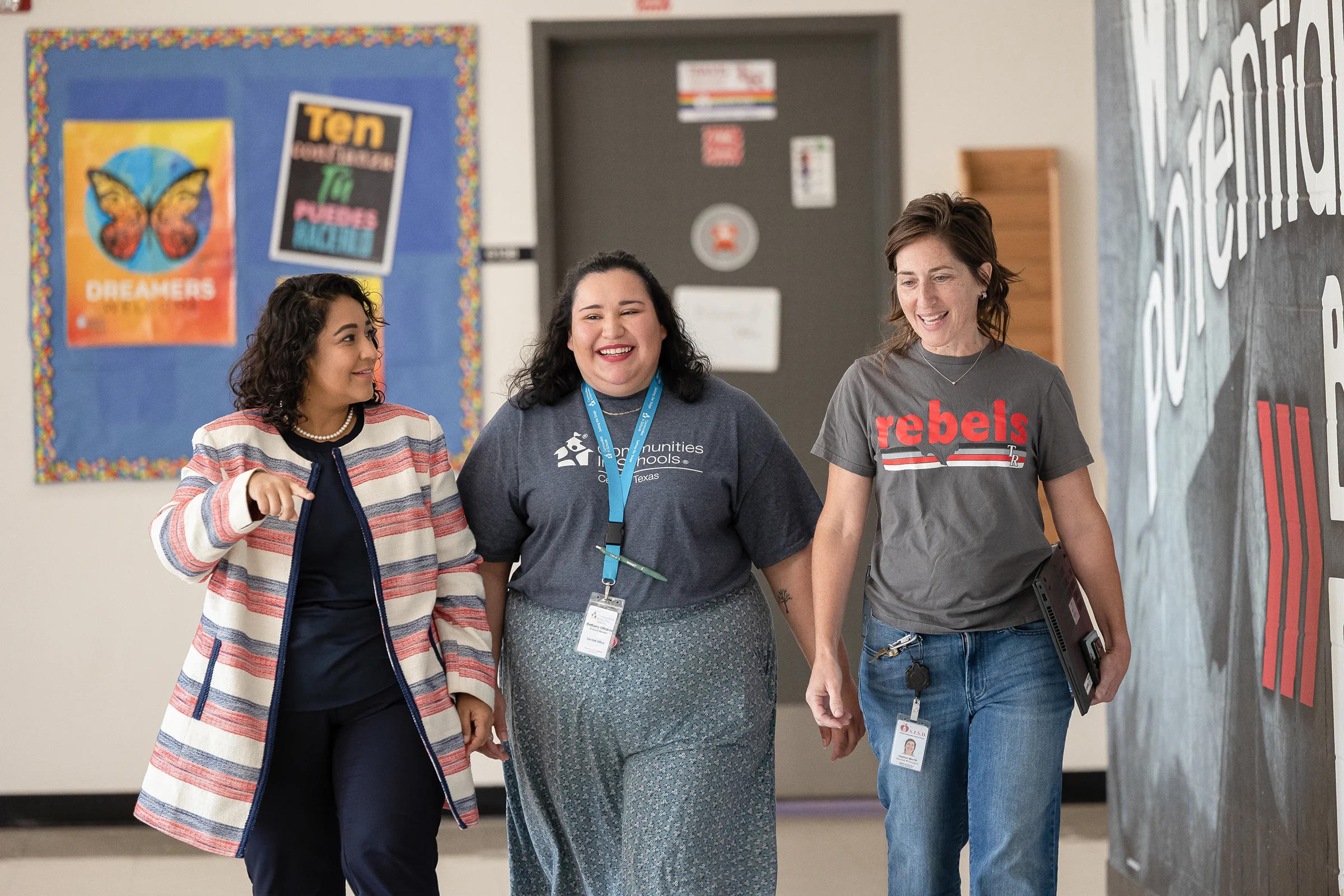 Communities in Schools staff walk down the hallway of a high school.