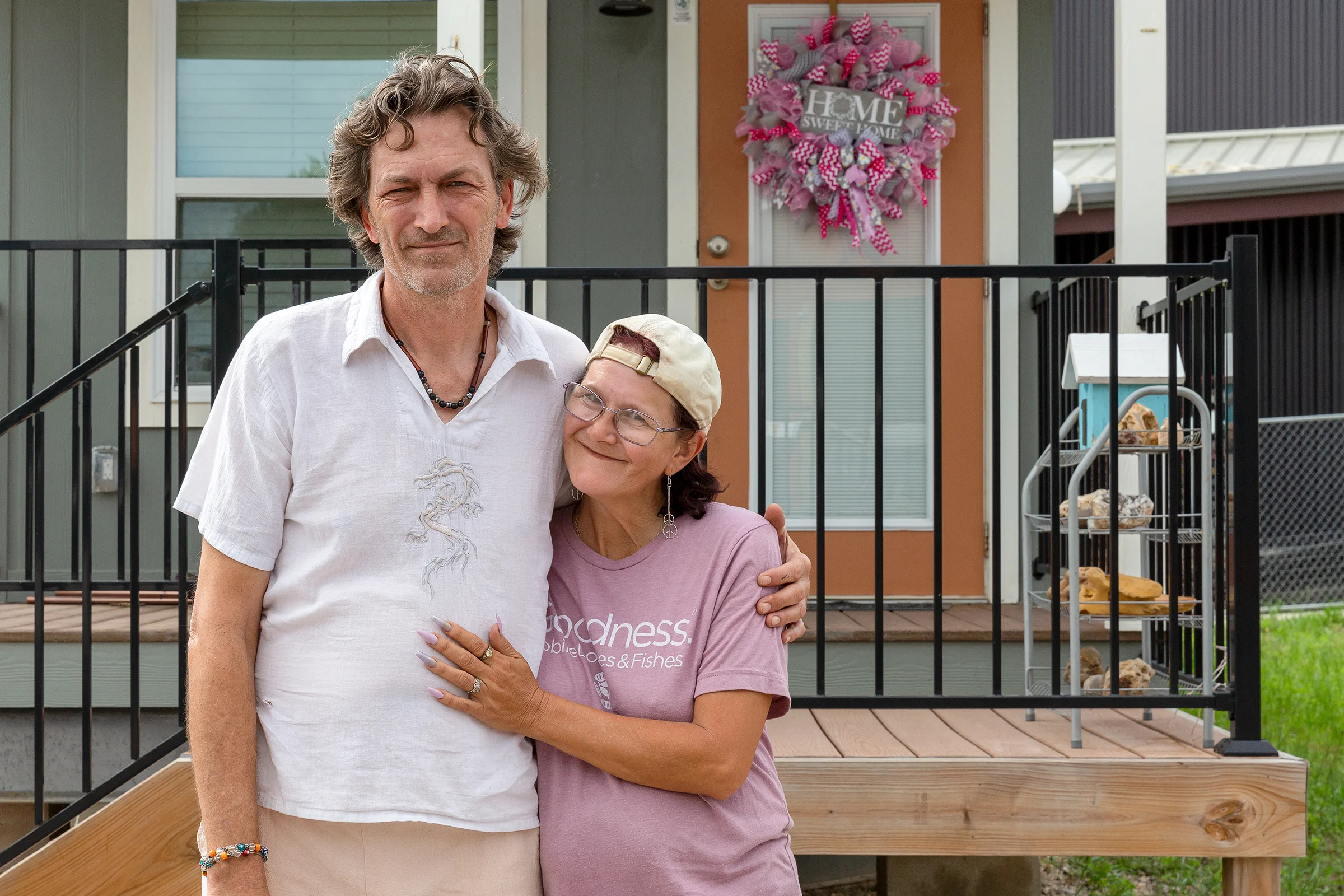 A man and a woman stand in front Community First! Village home.