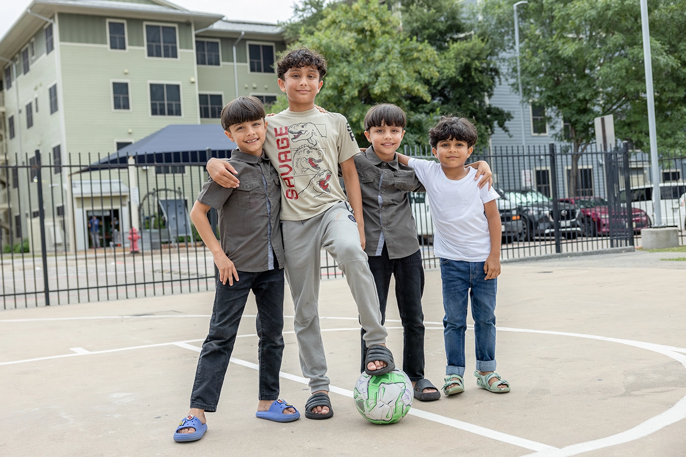 Four children pose together on a playground.