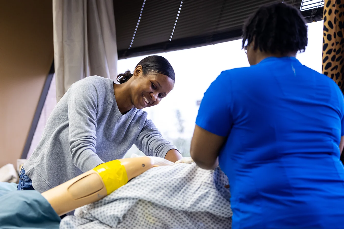 Two women participate in a medical assistant training program.